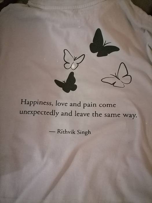 Back of a pale t-shirt printed with four butterflies and a quote by Rithvik Singh
