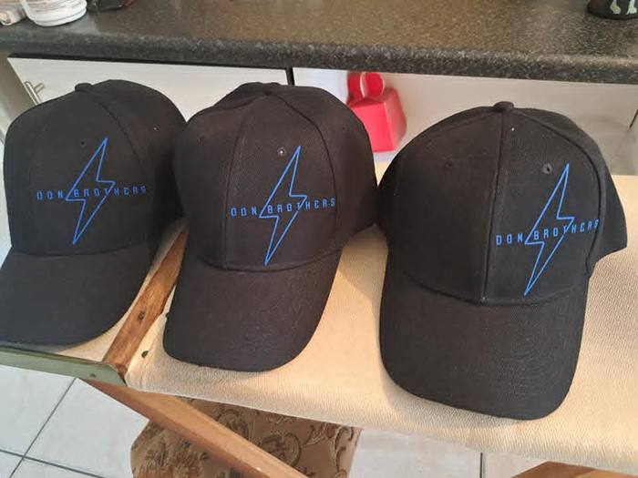 Three black caps printed with a blue lightning bolt and the name Don Brothers