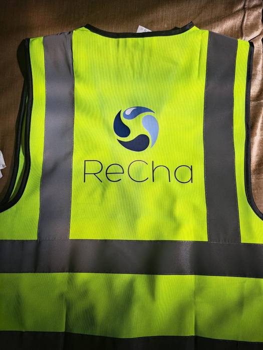 High-visibility yellow safety vest printed with the blue ReCha logo across the back